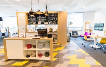 Moderne kantoorruimte in Eindhoven Airport met kleurrijk interieur en gezellige zithoek. Ideaal om te huren voor dynamisch kantoorwerk.