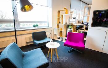 Moderne kantoorspace bij Flight Forum 40 in Eindhoven Airport, ingericht met kleurrijke stoelen en een stijlvolle lamp. Ideaal voor teams die kantoorruimte willen huren en een inspirerende werkomgeving zoeken.