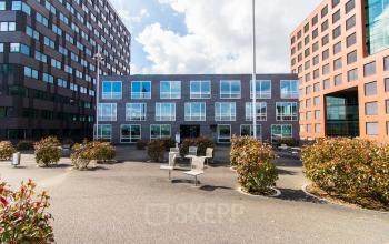 Moderne kantooromgeving op Flight Forum 40, Eindhoven Airport, met drie kantoorcomplexen en planten in de buitenruimte.