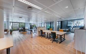 Moderne open kantoorruimte op Flight Forum 760-780 in Eindhoven Airport, ingericht met bureaus en stoelen, grote ramen, perfect voor flexibel werken of kantoren huren.