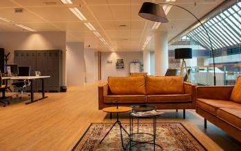 Gezellige kantoorlobby met comfortabele banken en moderne verlichting bij kantoorpand Flight Forum 760-780, Eindhoven, perfect om te gebruiken tijdens kantoorruimte huren voor meetings en ontspanning.