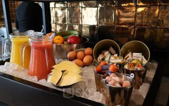 Een kantoorlounge in Eindhoven Airport met een verfrissend buffet met fruitsappen, eieren, kaas en fruit. Ideaal voor huurders die een kantoorruimte op Flight Forum 760-780 gebruiken.