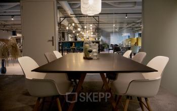 Vergaderruimte in Eindhoven Airport met moderne inrichting, stijlvolle verlichting en comfortabele stoelen rondom een lange tafel. Ideaal voor kantoorruimte huren in Flight Forum 760-780.