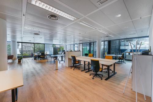 Moderne open kantoorruimte op Flight Forum 760-780 in Eindhoven Airport, ingericht met bureaus en stoelen, grote ramen, perfect voor flexibel werken of kantoren huren.