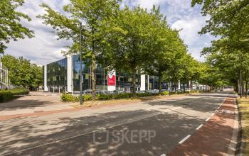 Modern kantoorpand aan Luchthavenweg 81, Eindhoven Airport, omgeven door groen en voorzien van eigentijdse architectuur. Een ideale locatie voor kantoorruimte huren in een inspirerende zakelijke omgeving.