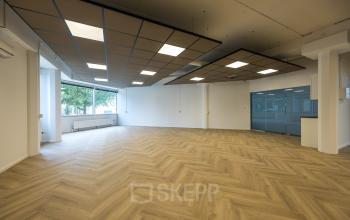 Ruime, lichte kantoorruimte te huur op Luchthavenweg 81, Eindhoven Airport, met modern houten vloerontwerp en grote ramen voor veel natuurlijk licht.