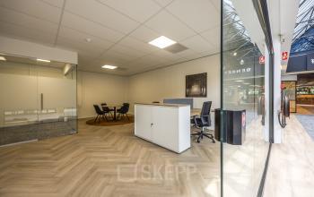 Stijlvolle kantoorruimte huren op Luchthavenweg 81, Eindhoven Airport. Ruimte met glazen wanden, moderne inrichting en houten vloer. Ideaal voor zakelijke bijeenkomsten en flexibel werkplekgebruik.