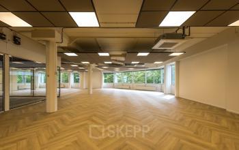Ruime en lichte kantoorruimte op Eindhoven Airport met een modern plafond ontwerp en grote ramen voor natuurlijk licht.