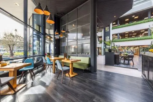Kantoorruimte met moderne tafels en stoelen bij Luchthavenweg 81, Eindhoven Airport, met grote ramen en veel lichtinval.
