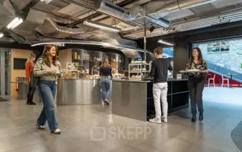Kantoorruimte op Flight Forum 120-159 in Eindhoven met moderne pantry en mensen bezig met koffie en snacks.