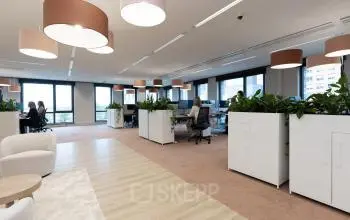Moderne kantoorruimte op Flight Forum 120-159, Eindhoven Airport met bureaus, kantoormeubilair en planten. Zakelijke professionals werken aan computers binnen deze lichte, productieve omgeving. Kantoorruimte huren in een inspirerende atmosfeer.