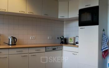 Foto van de pantry in het kantoorpand op Luchthavenweg 55, Eindhoven Airport, voorzien van keukenapparatuur zoals een waterkoker en een magnetron.