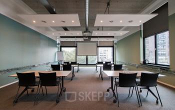 Modern ingerichte kantoorruimte in Lichttoren 32, Eindhoven Centrum, met meerdere tafels en stoelen, ideaal voor werkactiviteiten of vergaderingen. Grote ramen zorgen voor veel natuurlijk licht.