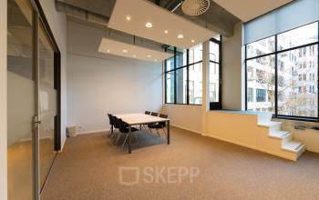 Licht, ruim kantoor op Lichttoren 32 in Eindhoven Centrum met grote ramen, vergadertafel en stoelen. Ideaal voor het huren van kantoorruimte met uitzicht over de stad.