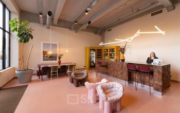 Moderne kantoorruimte op Lichttoren 32, Eindhoven Centrum met stijlvolle inrichting, inclusief designstoelen en een ontvangstbalie. Ideaal voor wie zoekt naar kantoorruimte huren in een kantoorpand met moderne voorzieningen.