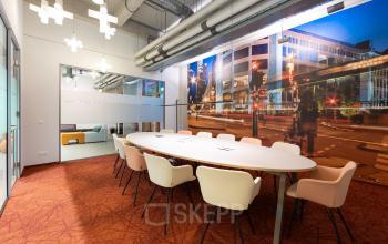 Vergaderruimte in Lichttoren 32, Eindhoven Centrum, met moderne inrichting en kleurrijk stadsbeeld op de muur, geschikt voor kantoorruimte huren.
