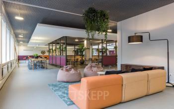 Kantoorruimte huren op Stadhuisplein 10, Eindhoven Centrum met moderne inrichting, kleurrijke zitgedeeltes en natuurlijke elementen, ideaal voor inspirerende werkplekken.