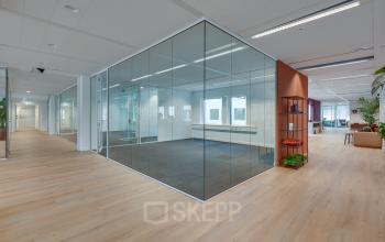 Ruime kantoorruimte in Eindhoven Centrum met glazen wanden, natuurlijke lichtinval en houten vloeren. Voorzien van moderne meubels en comfortabele zitplekken. Ideaal voor kantoorruimte huren aan Stadhuisplein 10.