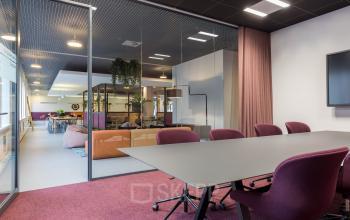 Modern kantoorpand op Stadhuisplein 10 in Eindhoven Centrum, met een stijlvolle vergaderruimte en comfortabele stoelen. Ideaal voor wie kantoorruimte wil huren met een professionele uitstraling.