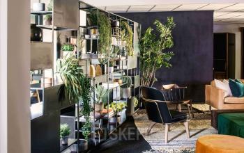 Moderne kantoorruimte huren op Emmasingel 33 in Eindhoven Centrum, voorzien van stijlvolle open lounge met planten en comfortabele meubels voor informele meetings en ontspanning.