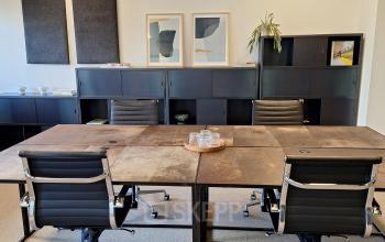 Moderne vergaderruimte in kantoorpand aan Emmasingel 33, Eindhoven Centrum, met stijlvolle stoelen en kunst aan de muur.