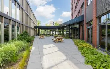 Kantoorpand op Professor Dr Dorgelolaan 14, Eindhoven Centrum. Ruime buitenplaats met moderne architectuur en groene accenten. Perfecte plek voor een pauze of informele ontmoeting. Geschikt voor wie kantoorruimte wil huren.