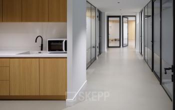 Kantoorruimte huren aan Paradijslaan 30-38 in Eindhoven Centrum met moderne glazen kantoorwanden, lichte vloer en een pantry met houten kasten. Geschikt voor diverse zakelijke activiteiten.