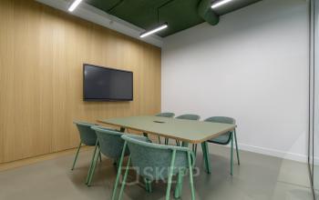 Moderne conferentieruimte met groene tafel en stoelen op Paradijslaan 30-38 in Eindhoven Centrum, perfect voor kantoorgebruik of vergaderingen.