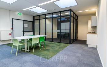 Kantoorruimte huren op Paradijslaan 30-38, Eindhoven Centrum, met glazen vergaderruimte en groene stoelen rond een witte tafel.