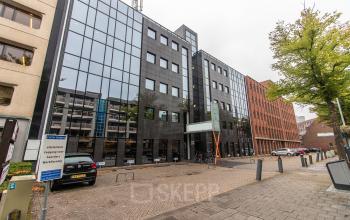 Extern zicht op kantoorpand Paradijslaan 30-38 in Eindhoven Centrum. Glas en steen gevel met parkeerplaatsen.