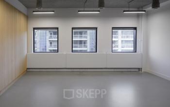 Lichte kantoorruimte met drie ramen en een houten wand in het kantoorpand aan de Paradijslaan 30-38, Eindhoven Centrum. Ideaal voor bedrijven die kantoorruimte willen huren.