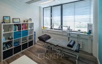 Kantoorruimte met een behandelstoel, opbergrek, en raam met jaloezieën op Noord Brabantlaan 303-307 in Eindhoven De Hurk.