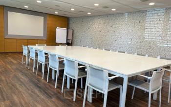Ruime vergaderruimte in een kantoorpand aan Noord Brabantlaan 303-307 in Eindhoven De Hurk, met een grote tafel en witte stoelen. Perfect voor het huren van kantoorruimte.