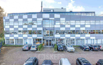 Voorzijde van het kantoorpand op Meerenakkerplein 1-10 in Eindhoven De Hurk met parkeerplaatsen voor het gebouw.