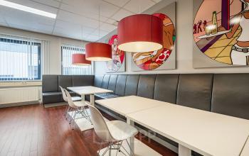 Stijlvolle kantoorpand in Eindhoven De Hurk met houten vloer, kleurrijke muurschilderingen en moderne verlichting. Geschikt voor kantoorruimte huren.