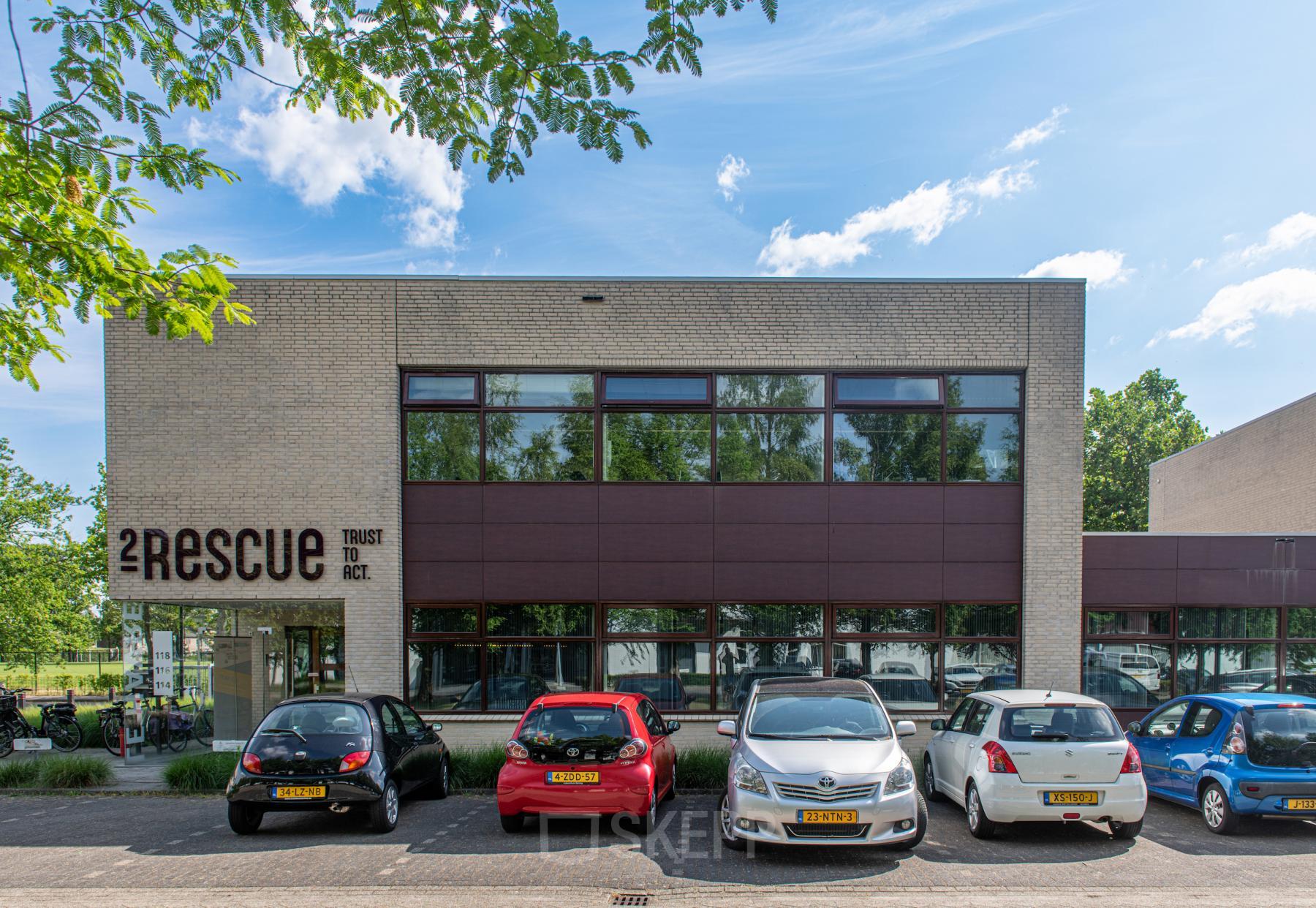 Voorzijde van het kantoorpand bij Le Havre 114-127 in Eindhoven Noord met verschillende geparkeerde auto's.