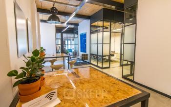 Modern kantoorpand in Eindhoven Noord met glazen wanden en planten voor een frisse uitstraling. Ideaal voor wie kantoorruimte wil huren op Weegschaalstraat 3. Heldere werkplekken met wifi mogelijkheden.