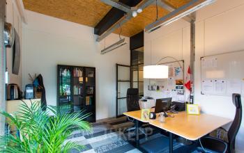 Gemeubileerd kantoor in Eindhoven Noord met houten bureau, ergonomische stoelen en een boekenkast, ideaal voor kantoorruimte huren.