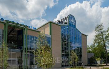 Vooraanzicht van modern kantoorpand op Frederiklaan 10A, Strijp-S, Eindhoven. Grote glazen gevel met industriële uitstraling, ideaal voor wie kantoorruimte wil huren in een innovatieve omgeving.