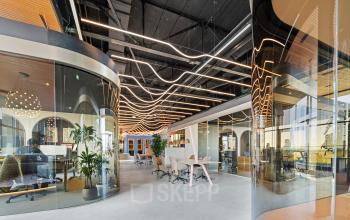 Moderne kantoorruimte met glazen wanden en unieke verlichting in kantoorpand op Achtseweg Zuid 159R, Eindhoven Strijp-S, ideaal voor het huren van inspirerende werkplekken.