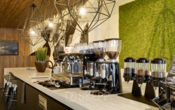 Gezellige koffiehoek in kantoorpand op Frederiklaan 10E, Eindhoven Strijp-S. Ideaal voor ontspannen pauzes tijdens het kantoorwerk. Moderne espressomachine en sfeervolle verlichting aanwezig.