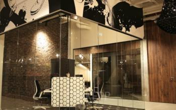 Modern kantoorpand op Frederiklaan 10E, Eindhoven Strijp-S, met glazen wanden en stijlvolle inrichting. Geschikt voor kantoorruimte huren. Sfeervolle verlichting en decoratieve elementen geven de ruimte een professionele uitstraling.