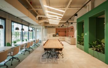 Moderne en lichte kantoorruimte op Frederiklaan 10E, Eindhoven Strijp-S, met lange tafels, comfortabele stoelen en een open keuken. Geschikt voor kantoorruimte huren zonder aanwezige personen.