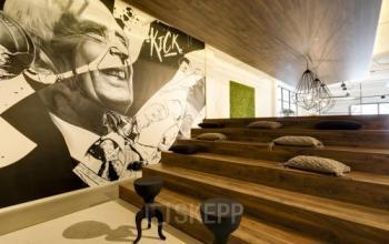 Unieke kantoorruimte huren in Eindhoven Strijp-S op Frederiklaan 10E, met houten trappen en kleurrijke muurschilderingen. Ideale plek voor creatieve bijeenkomsten.