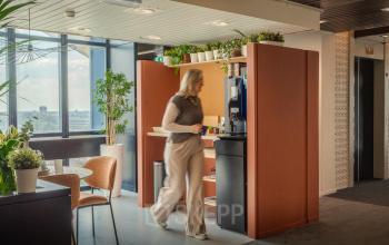 Moderne kantoorruimte in Eindhoven Strijp-S met een gezellige zithoek, veel groen en uitzicht op de stad, ideaal voor het huren van een inspirerend kantoorpand.
