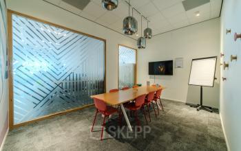 Vergaderruimte in kantoorpand op Torenallee 20, Eindhoven Strijp-S, met een grote tafel en stoelen, geschikt voor kantoorruimte huren.