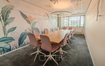 Modern ingerichte vergaderruimte in Eindhoven Strijp-S op Torenallee 20, met een grote tafel en comfortabele stoelen. Perfecte plek voor kantoorruimte huren.