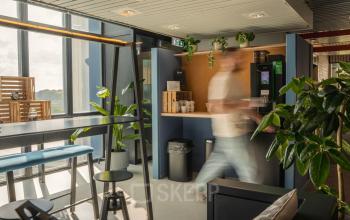 Moderne kantoorpand in Eindhoven Strijp-S met levendig interieur, hoge ramen en een mix van zitopties. Groenvoorziening geeft een frisse sfeer. Ideaal voor kantoorruimte huren.