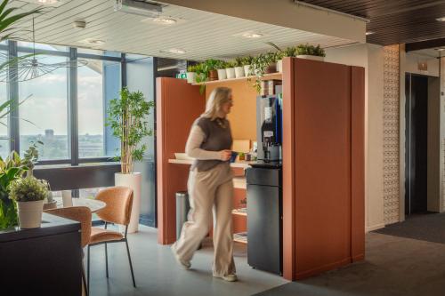Moderne kantoorruimte in Eindhoven Strijp-S met een gezellige zithoek, veel groen en uitzicht op de stad, ideaal voor het huren van een inspirerend kantoorpand.