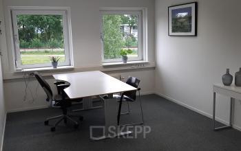 Kantoorruimte huren aan Hoenderkamp 20 in Emmen; licht en functioneel ingericht met bureaus en stoelen, uitzicht op groen.